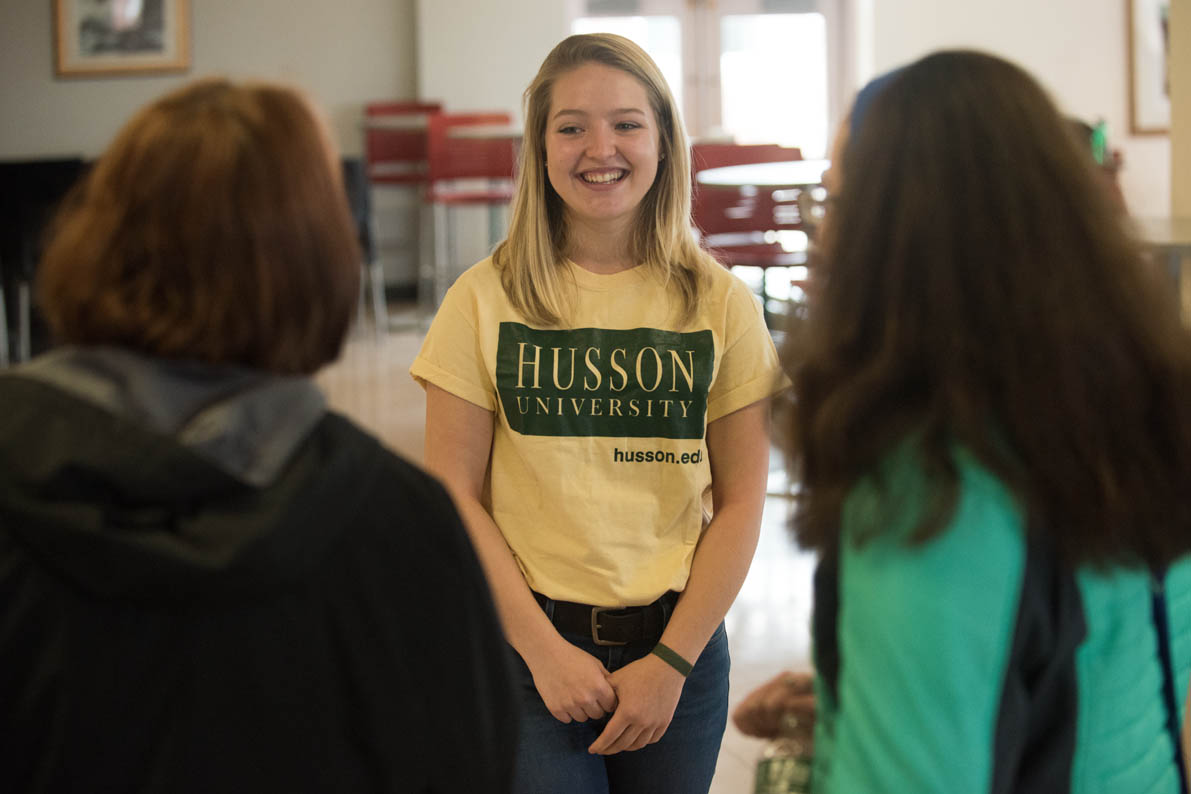 Eagle Ambassador talking with student and parent in the Campus center