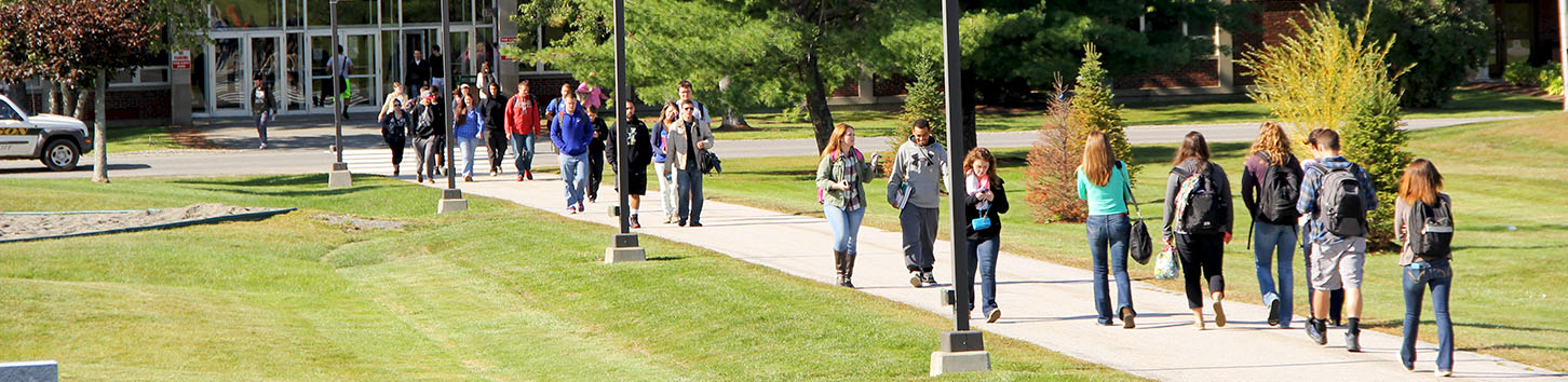 Student walking in on the campus of Husson University