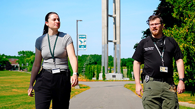 two safety and security employees walk by the bell tower